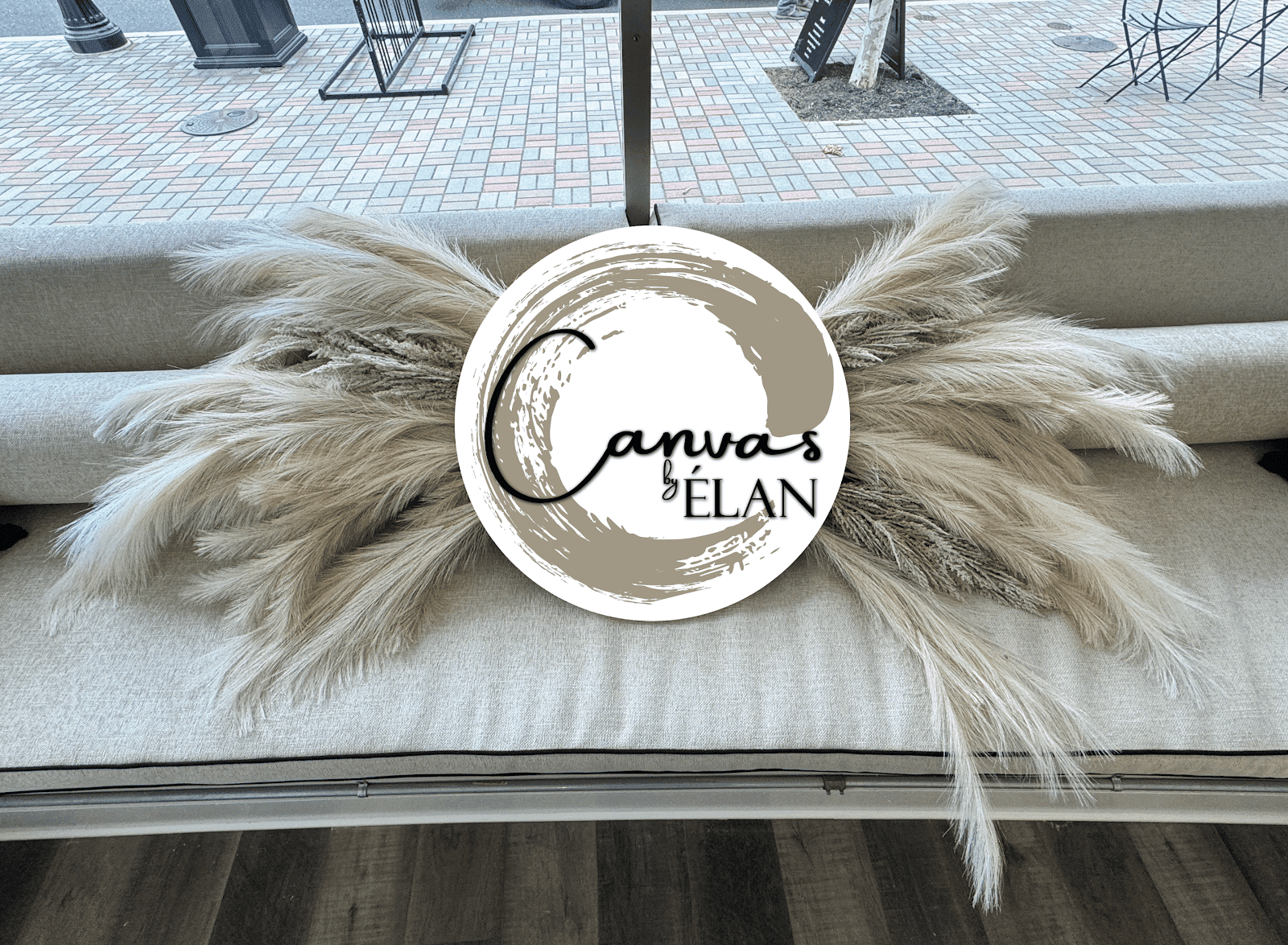 Dry grasses and decorative logo on a light-colored couch in a modern setting.